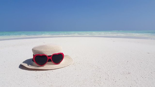 Hat with red sunglasses on white sandy tropical beach, summer vacation and travel concept from Thailand