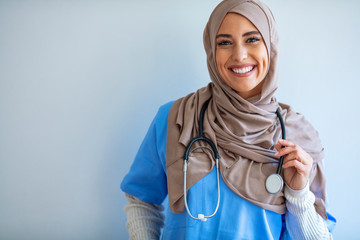 Portrait Of Smiling Muslim Female Doctor. Confident female nurse. Closeup portrait of friendly, smiling confident muslim female doctor. Arab female Doctor. Arab female nurse posing and smiling - obrazy, fototapety, plakaty