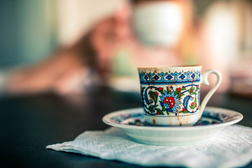 Small ornamental Traditional cup with strong turkish coffee close up view.
