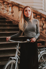 Stylish autumn fashionable image of a girl. Gray blazer and pleats skirt. Blonde woman, white...