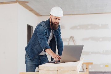 Engineer or architect working on a laptop on site