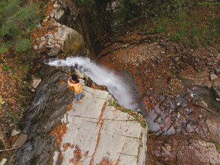 woman on the cliff looking at waterfall enjoying the view