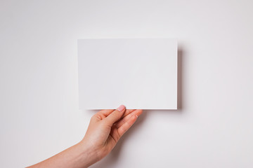 Woman's hand holding blank paper close-up