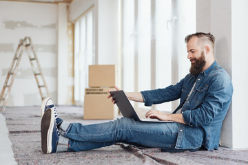 Young man in a new home sitting on the floor
