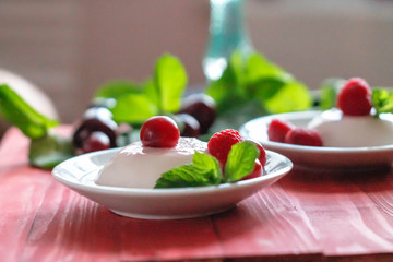 Panacota decorated with raspberries and mint