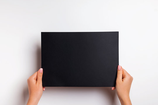 Woman's Hands Holding Blank Black Color Paper