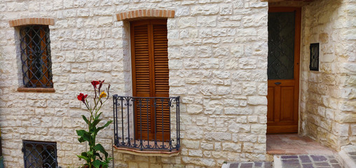 Fototapeta na wymiar Stone house with balcony, in the old town of a characteristic Adriatic place in Italy.