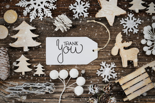One White Label With English Text Thank You. Frame Of Christmas Decoration Like Tree, Sled, Star And Fir Cone. Wooden Background With Snowflakes