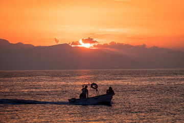 Fishing boat sailing in the sunset over the Tyrrhenian Sea in Cefalu, Sicily