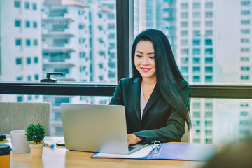 Asian Businesswomen using laptop computer notebook working at Desk in office