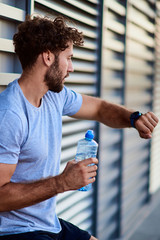 Sportsman making pause during exercising in urban area.