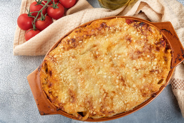 Traditional italian canelonni with vegetables, minced meat and cheese. On a wooden background. Top view, copy space