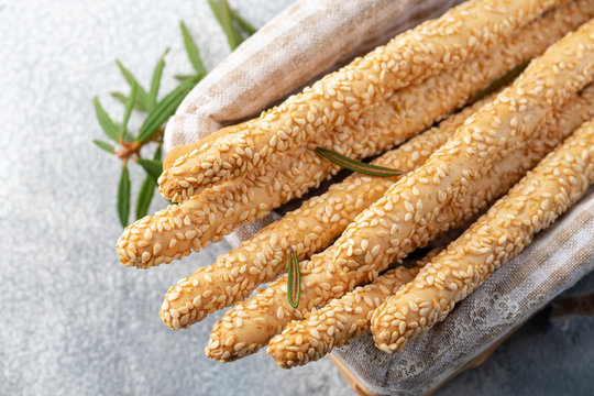 Italian grissini or salted bread sticks in the basket on a light stone background. Fresh italian snack. Copy space