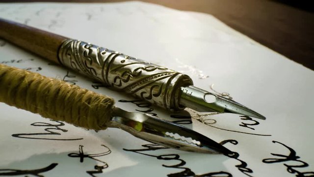 Calligraphy in slow motion. Pan shot of hand written page. Vintage ink pen and quill pen
