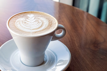 Fresh cappuchino or flat white coffee in a white cup with latte art