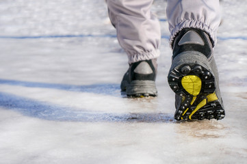 male or female winter boots walking on snowy sleet road