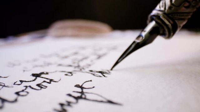 Calligraphy close up. Writing with pen and black ink on white paper