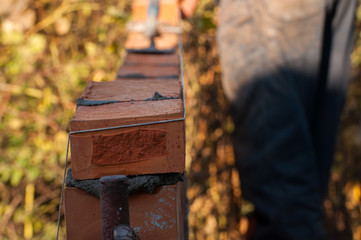 Building a wall with red brick. Working with bricks for building a wall, Construction tools