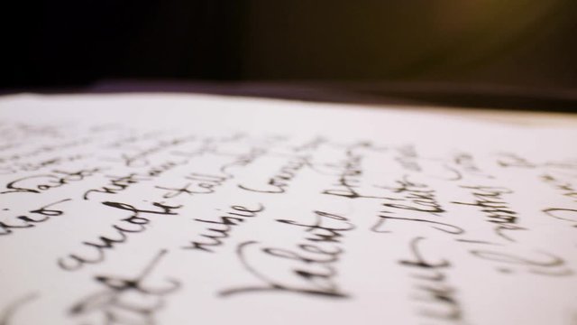 Calligraphy in slow motion. Pan shot of hand written page. Vintage ink pen and quill pen