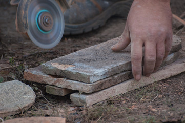 Worker cutting a tile using an angle grinder.Construction tool