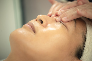 Naklejka premium Closeup Asian woman doing treatment in beauty shop.