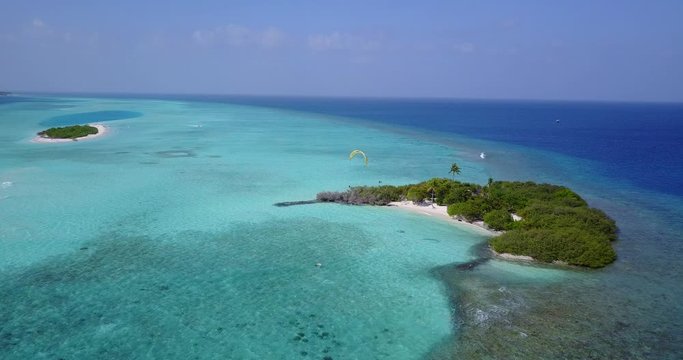 Paraglider, Flying Over Tropical Sea Coast, small uninhabited islands and turquoise shallow sea water