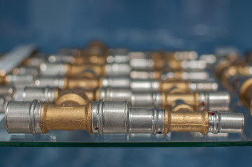T-shaped metal fittings of different sizes in two rows of photos with a blurred background