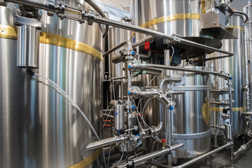 Stainless steel brewing tanks and equipment, iron reservoirs and pipes in modern beer factory