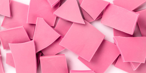 A panorama of ruby chocolate slices, overhead shot on a white marble background