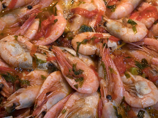 Shrimps fried on pan with fresh herbs and tomatoes.