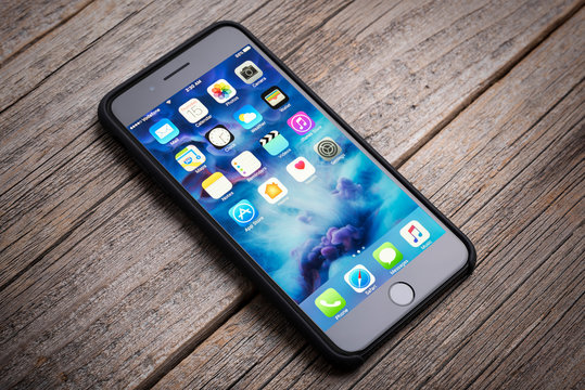 UZHGOROD, UKRAINE - DECEMBER 15, 2016: New black iPhone 7 Plus from the company Apple on a woden background, studio photo, on December 15, 2016 in Uzhgorod, Ukraine.