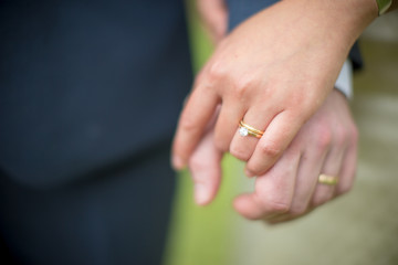 Close up hands of bride and groom. Image selective focus.