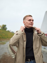 Autumn mood, young guy in a raincoat trench coat underground, street style.