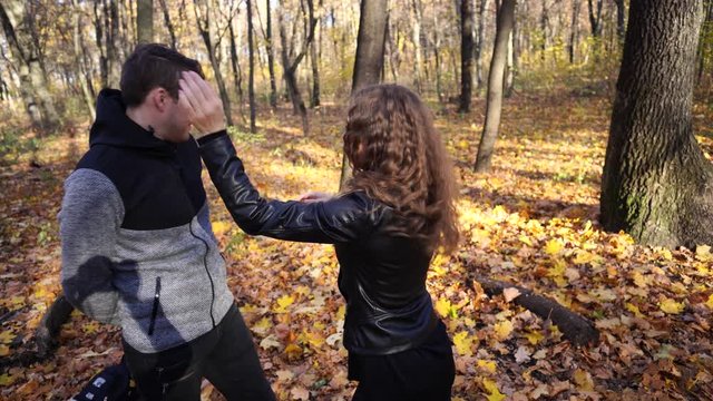 A woman slaps a man in the face. An emotional male is getting slapped in face, crouching his face with closed eyes in a fear.