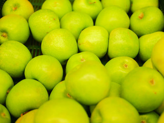 ripe green apples on the counter. Collection of green apples in a shop window. close-up. New Year fruit concept, freshly squeezed vitamin juice