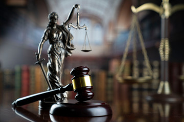  Law and justice theme.  Gavel of  the judge, Themis statue and the scale on court library background.