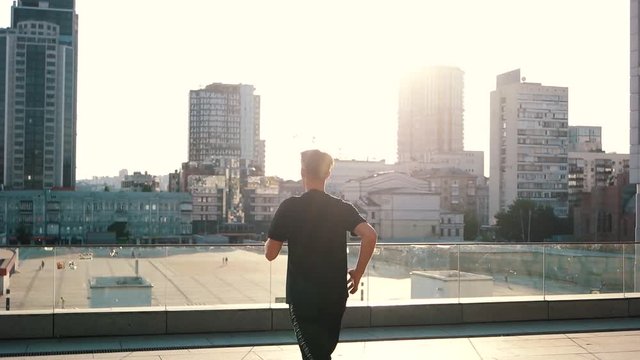 guy runs in the city at sunset