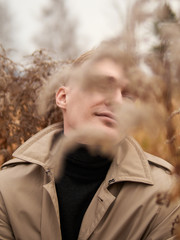 Autumn mood, young guy in a raincoat trench coat underground, street style.