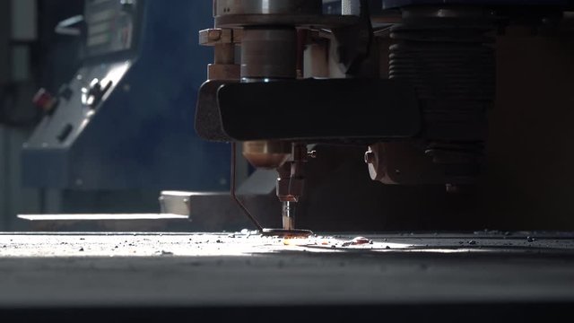 CNC plasma cutter moves above preheated metal close view