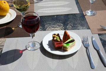 Red, white wine in a glass and a cake on a glass table.The concept of the aperitif and dinner parties.Copy space for your text