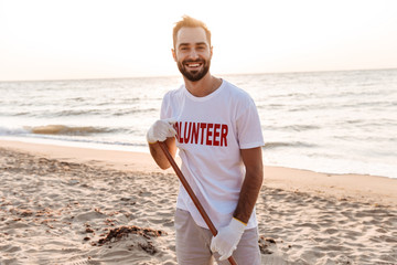 Young man volunteer standing at the beach