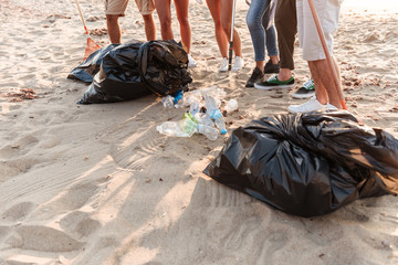 Group of young friends volunteers cleaning beach