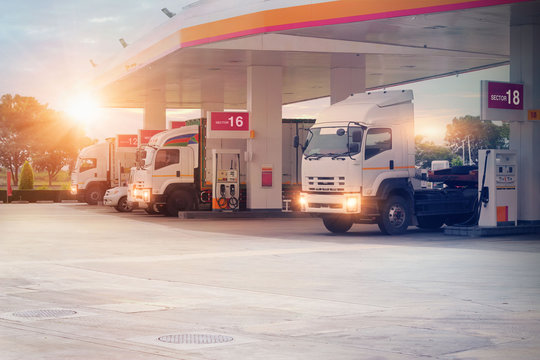 Trucks refueling in petrol station, Transportation vehicle, Business logistics, delivery transport, cargo logistic concept. Freight shipping, at sunset background.