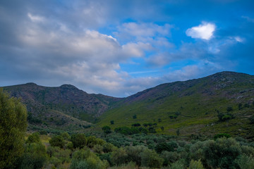 Mountain landscape on blue cloudy sky background. Mountain meadows in the setting sun. Night descends in the Pyrenees. Mediterranean landscape.