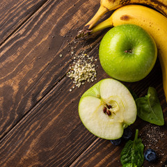 Ingredients fot healthy breakfast detox green smoothie bowl from banana, apples and spinach on wooden background. View from above.