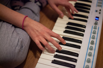 Piano playing. The girl’s hands are sorting the keys. Game on the host at home. Music lessons....