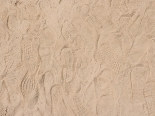 Fototapeta na wymiar Sand background texture with shoe marks