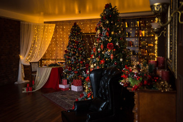 Decorated for the new year interior of the house-the General plan. Christmas tree and decorated Studio, lights garlands, decorations, gift boxes in a cozy home.