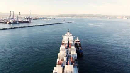 i Container ship at anchorage during bunkering at Algeciras anchorage. Vessel size 2100 TEU, L - 190 mtr, W - 30 mtr. Container Terminal behind the ship.