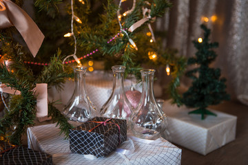 Christmas toys, garlands and interior elements in lights, home decoration for the holiday. Tied cinnamon sticks, kerosene lamp, glowing stars, lights in the side.